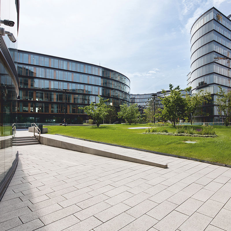 Chodník pri zelenej ploche s Largo podlahovou platňou bielo-čierne kamenivo pri Erste Group/Erste Campus Friedl Steinwerke.
