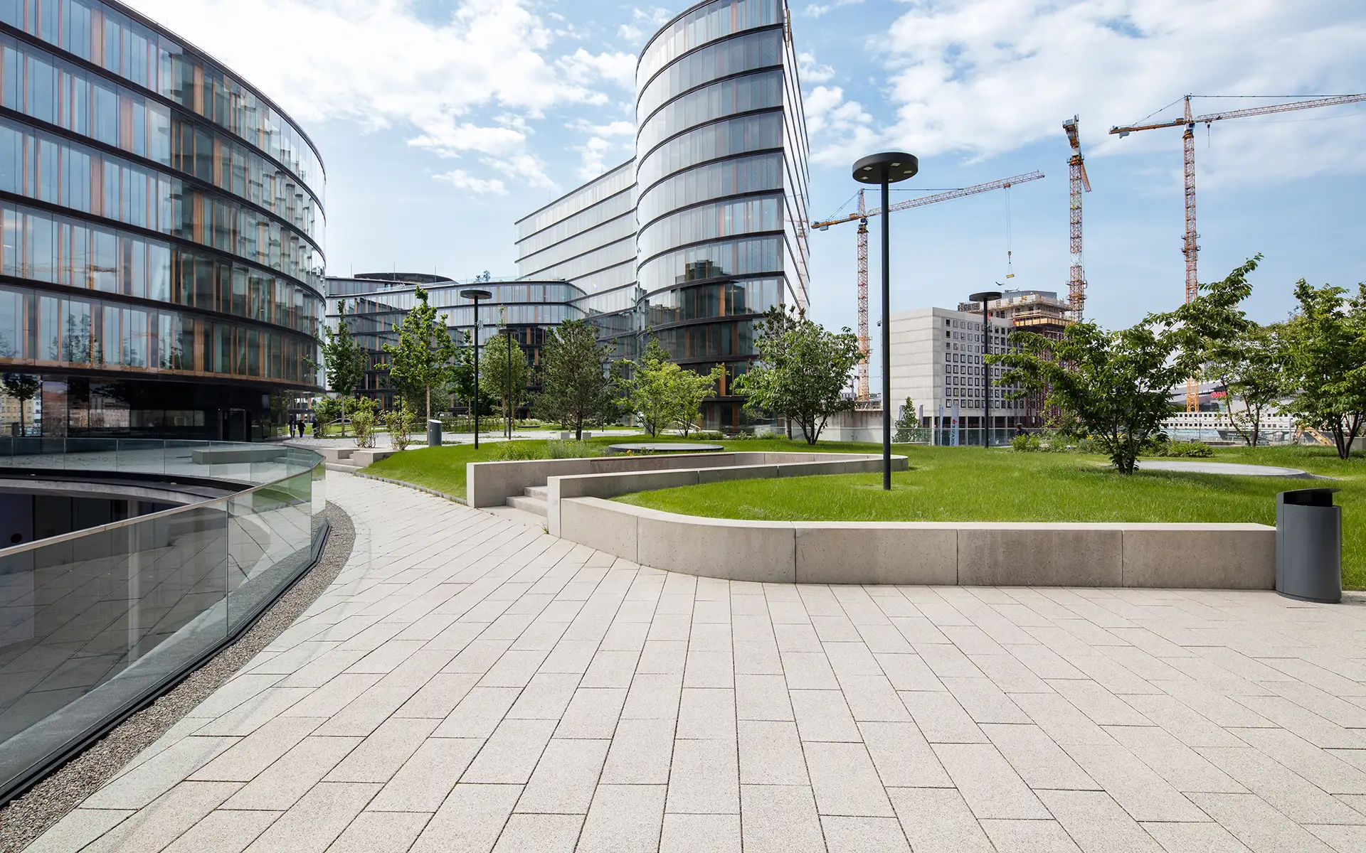 Chodník pri zelenej ploche s Largo podlahovou platňou bielo-čierne kamenivo pri Erste Group/Erste Campus Friedl Steinwerke.