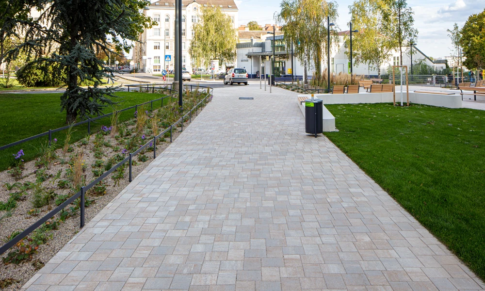 Dlažobné kocky s technológiou reduNox od spoločnosti Friedl v parku Ludwiga Zatzku vo Viedni Pohľad na park s peknou dlažbou a stromami.