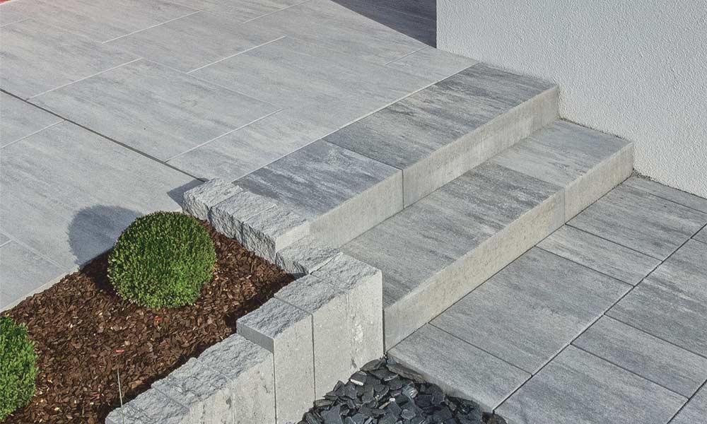 Campus VG4, žulovo sivá tieňovaná; Linea blokový schod, žulovo sivá tieňovaná, Gutshof Palisáda štiepaná, žulovo sivá tieňovaná a Largo podlahová platňa, ľadovo sivá tieňovaná Campus VG4, žulovo sivá tieňovaná; Linea blokový schod, žulovo sivá tieňovaná, Gutshof Palisáda štiepaná, žulovo sivá tieňovaná a Largo podlahová platňa, ľadovo sivá tieňovaná