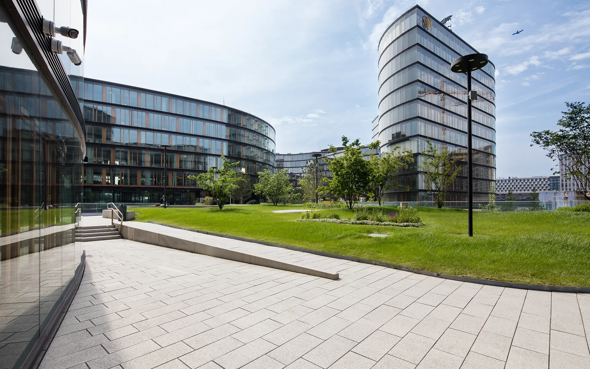 Chodník pri zelenej ploche s Largo podlahovou platňou bielo-čierne kamenivo pri Erste Group/Erste Campus Friedl Steinwerke.