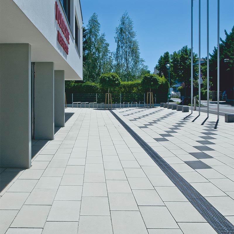 Volkschule Wiener Neudorf Magnum, sivá-antracitová betónové dlažby Friedl Steinwerke Volkschule Wiener Neudorf Magnum, sivá-antracitová betónové dlažby Friedl Steinwerke