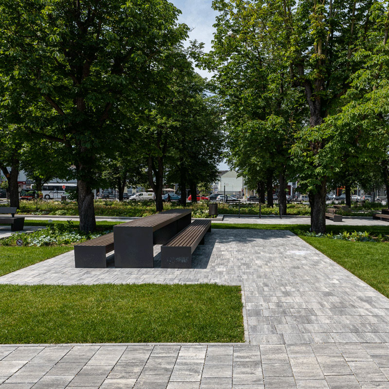 Mestský park Oberwart s lavičkami a chodníkmi pod stromami; Arret B25 VG4 kombinovaná dlažba, žulovo sivá tieňovaná, Friedl Steinwerke.